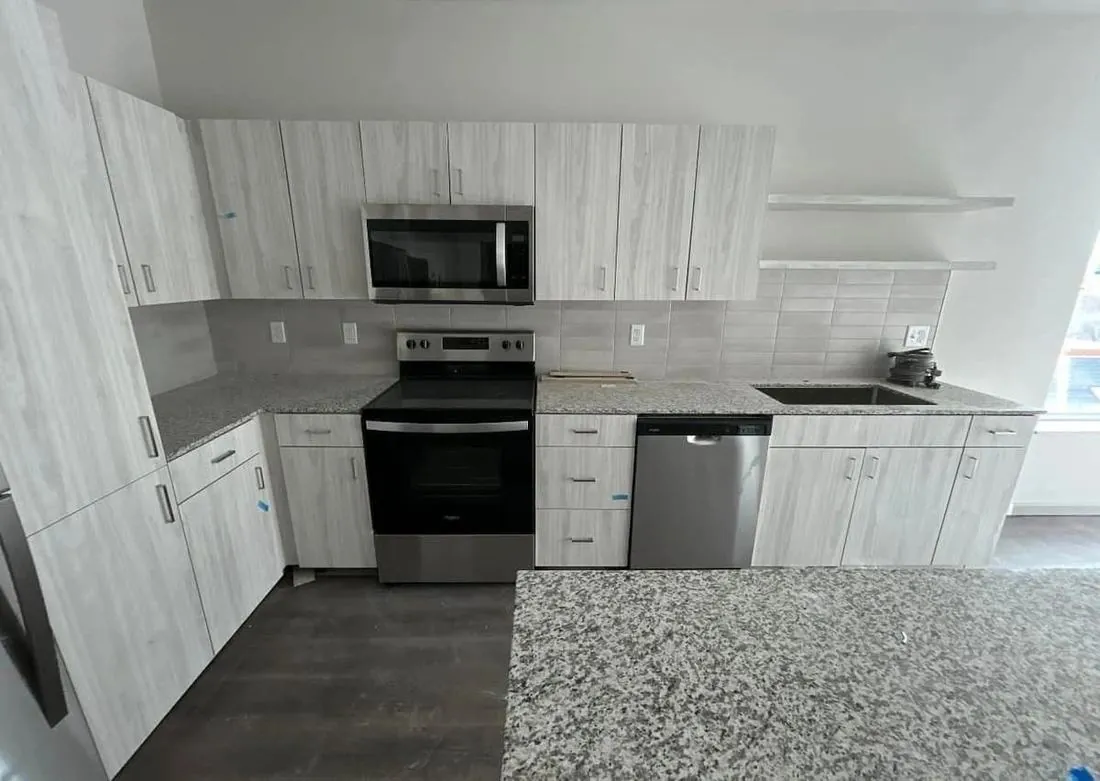 Finished kitchen with white cabinetry and granite counters