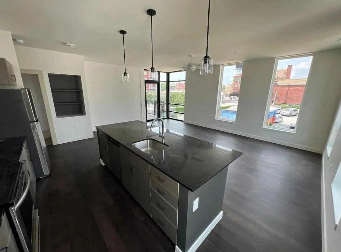 Finished kitchen with dark island and pendant lighting